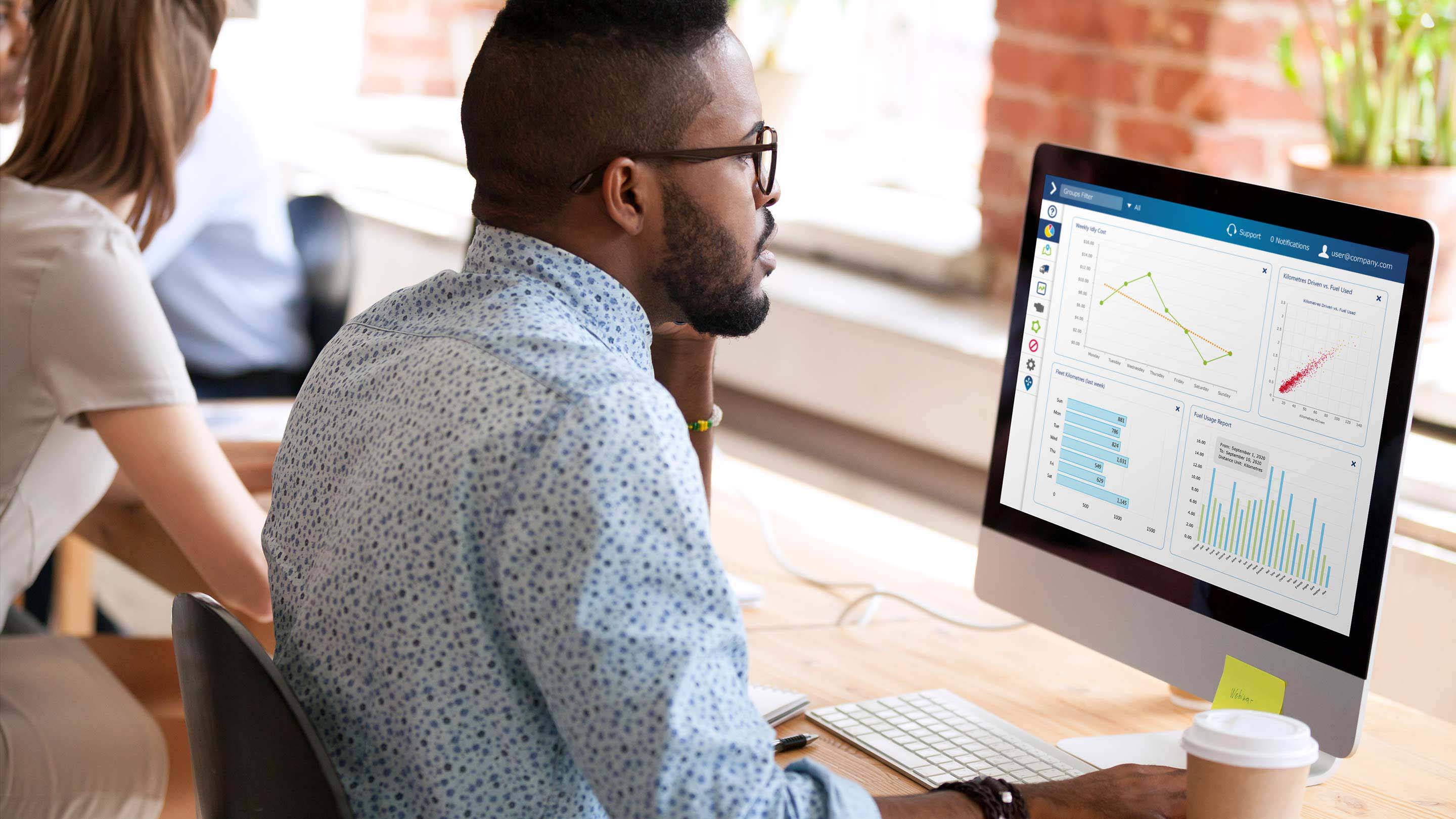 Man using MyGeotab Dashboard on a desktop computer