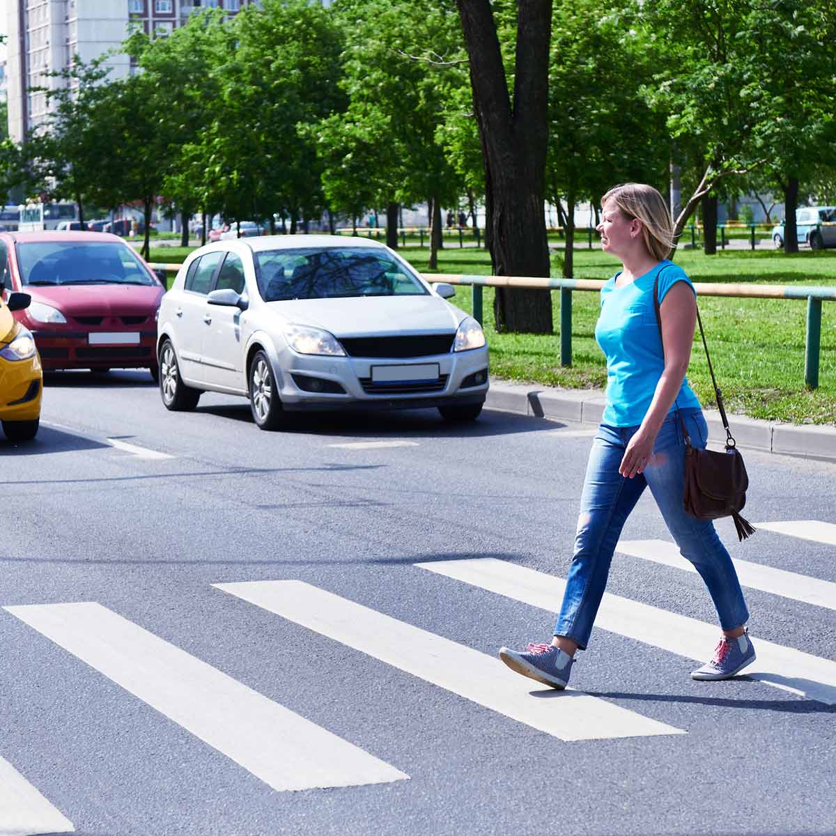Mujer cruzando la carretera por un paso de cebra