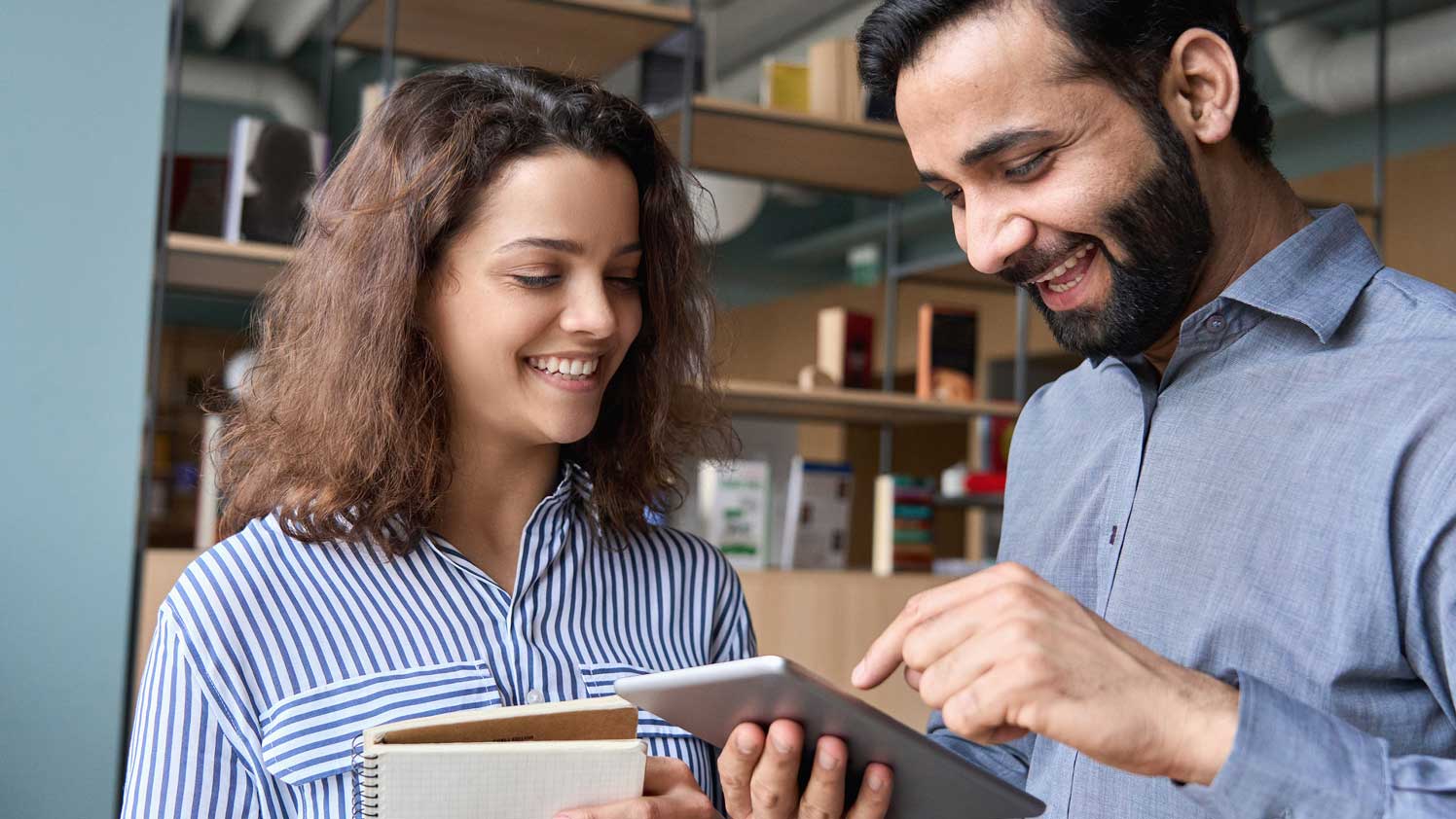 Man and woman looking at tablet smiling