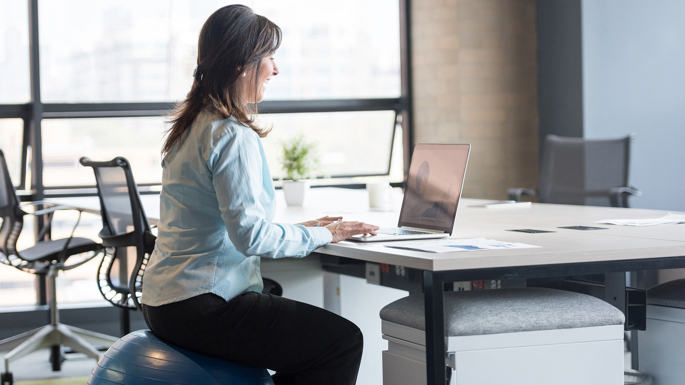 Woman working while on exercise ball