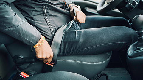 Image of a driver buckling a seat belt.