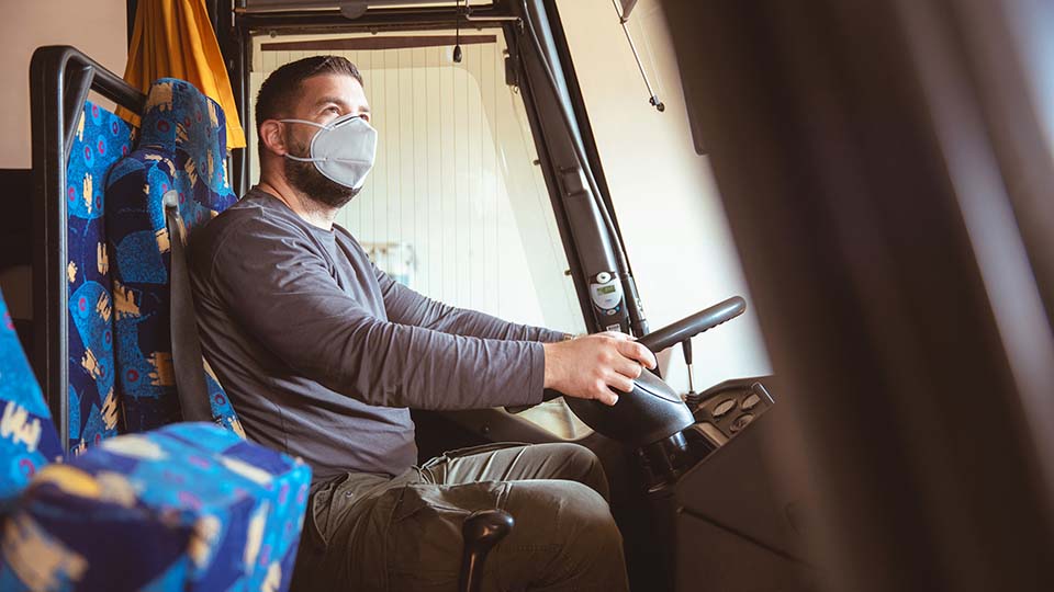 A man wearing face mask in a truck
