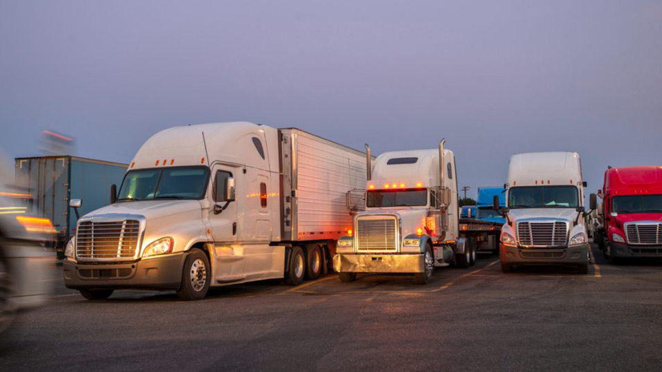 Four semi trucks driving side by side