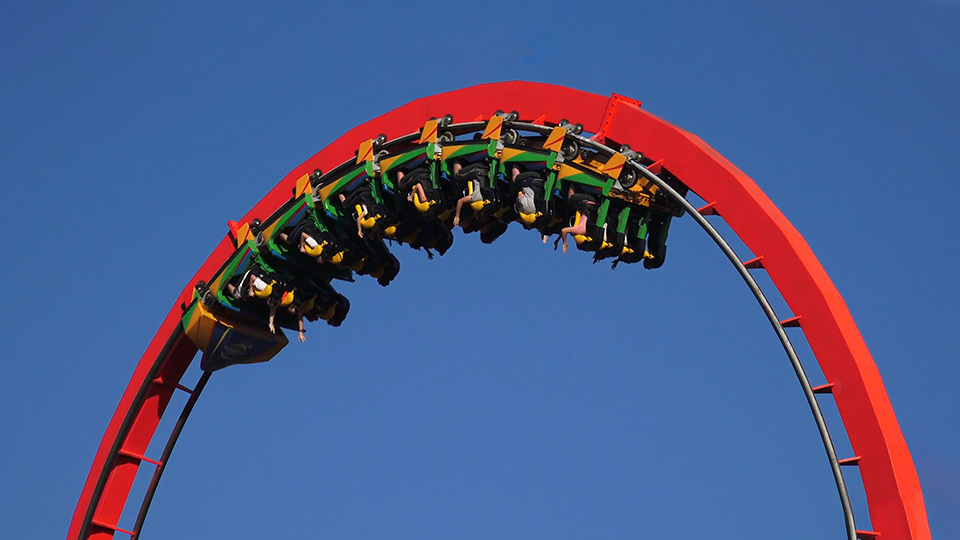 A a red roller coaster with the cart going upside down using g-force.