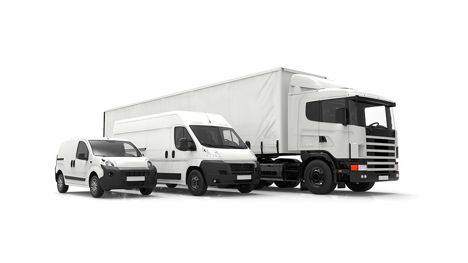 Um carro, uma van de entrega e um caminhão de transporte próximos um do outro