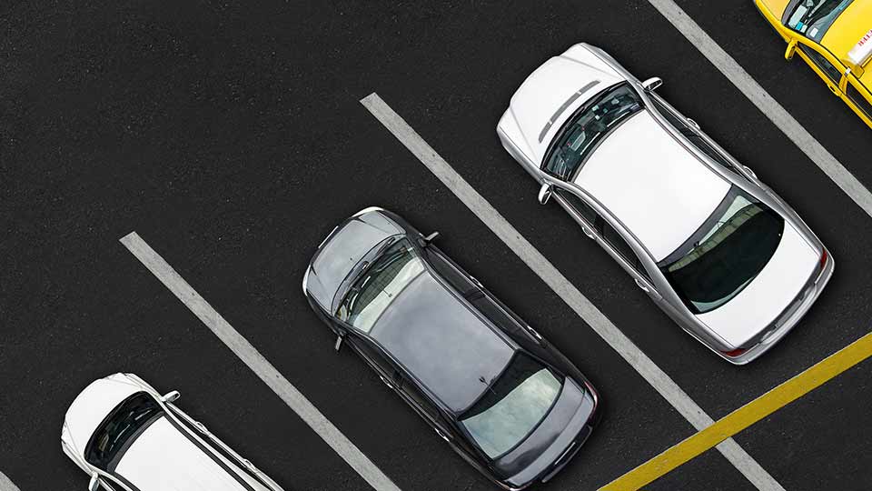 macchine parcheggiate su strisce bianche fotografate dall'alto