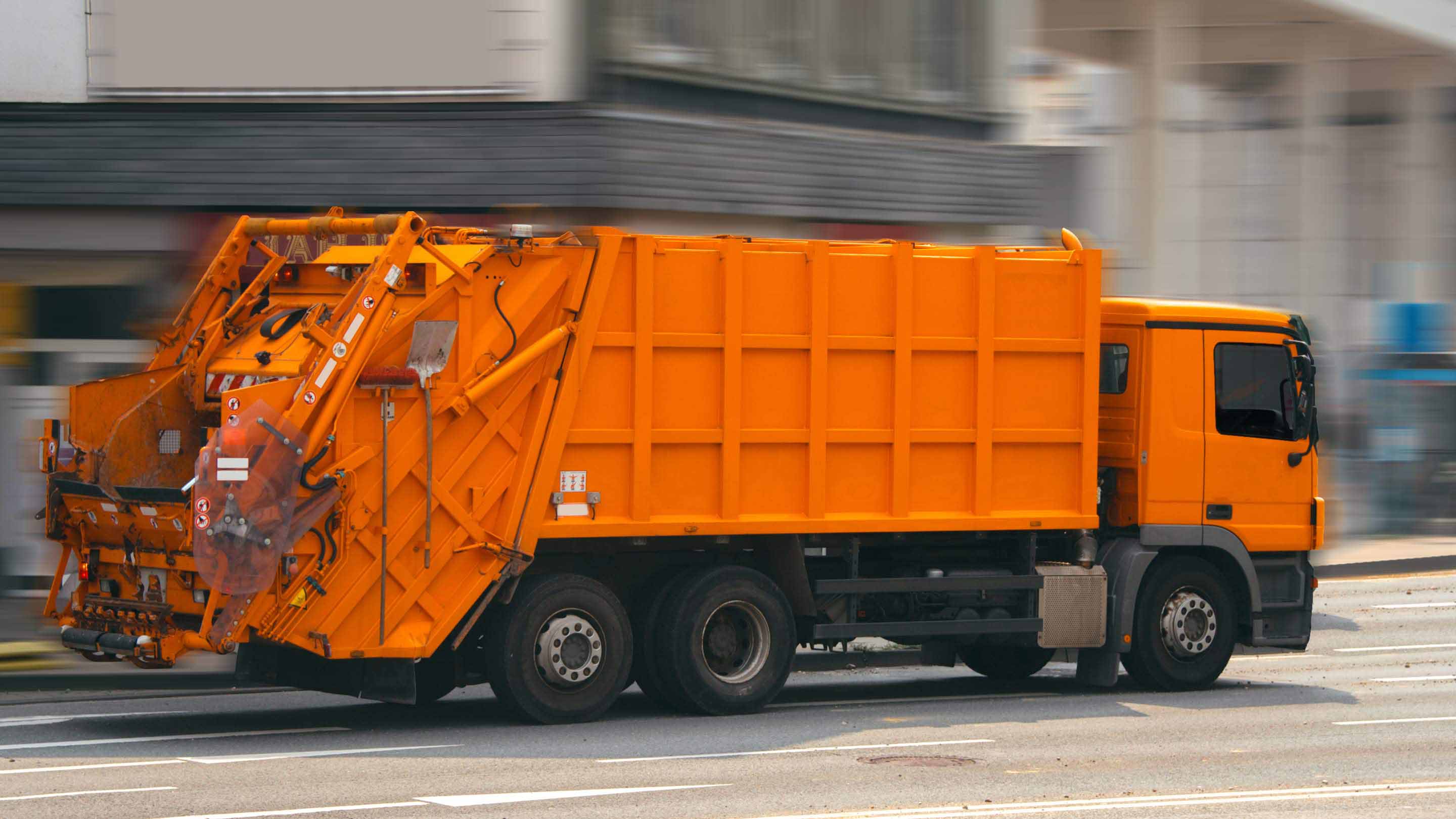 Orangener Müllabfuhrwagen.