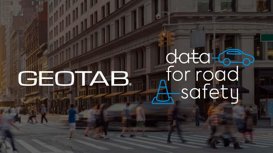Geotab and data for road safety logo on a background that shows a street with people crossing the road