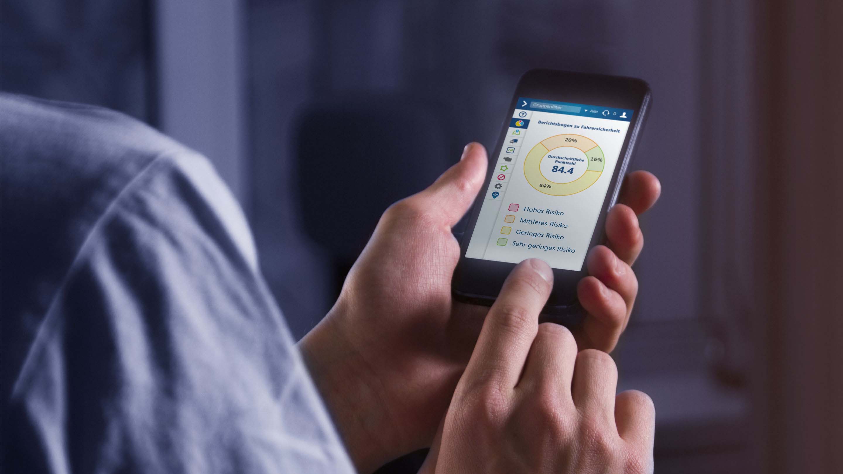 Person, die per Mobiltelefon den Berichtsbogen zu Fahrersicherheit in MyGeotab prüft