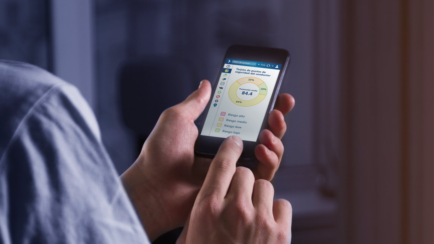 Persona utilizando un teléfono móvil para comprobar la tarjeta de puntuación de seguridad del conductor en MyGeotab