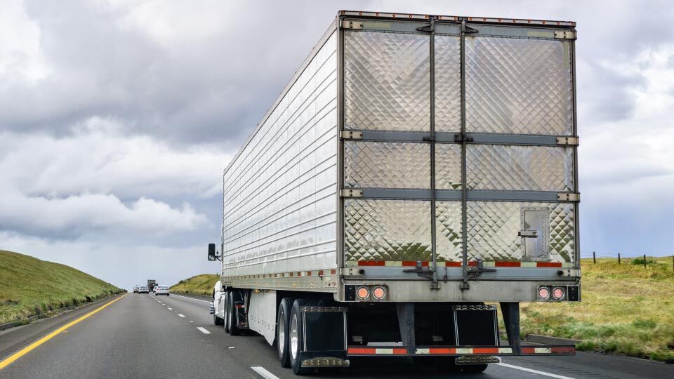 Imagen de un camión circulando en una carretera en un día nublado
