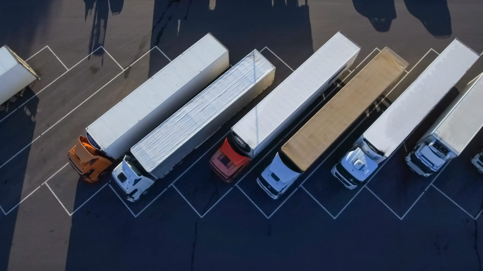 Foto aérea de seis camiones pesados estacionados uno al lado del otro.