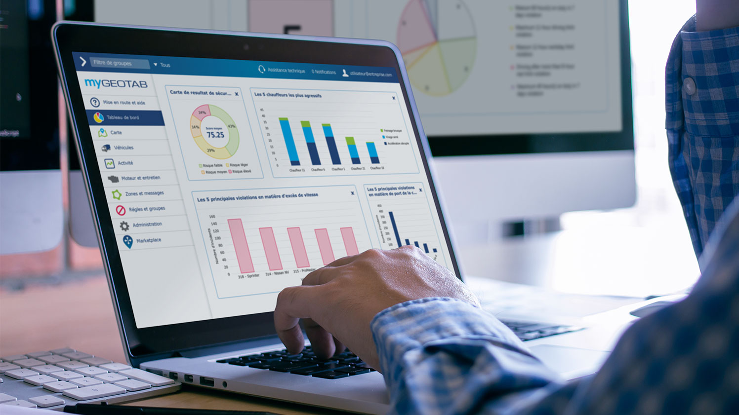 Tableau de bord des rapports dans MyGeotab Homme utilisant MyGeotab pour analyser les rapports de flotte sur son ordinateur portable