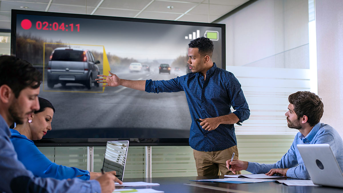 Dash cam footage being displayed in a board room being used as a training tool