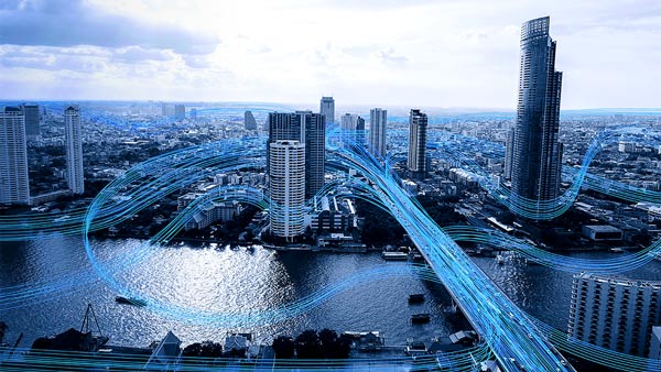 Foto di una città con scie blu che indicano veicoli in movimento e il trasferimento dei dati