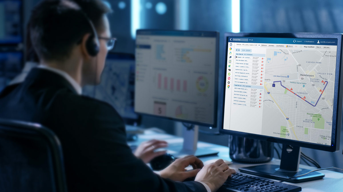 Hombre navegando por el panel de gráficos de MyGeotab en un monitor de ordenador