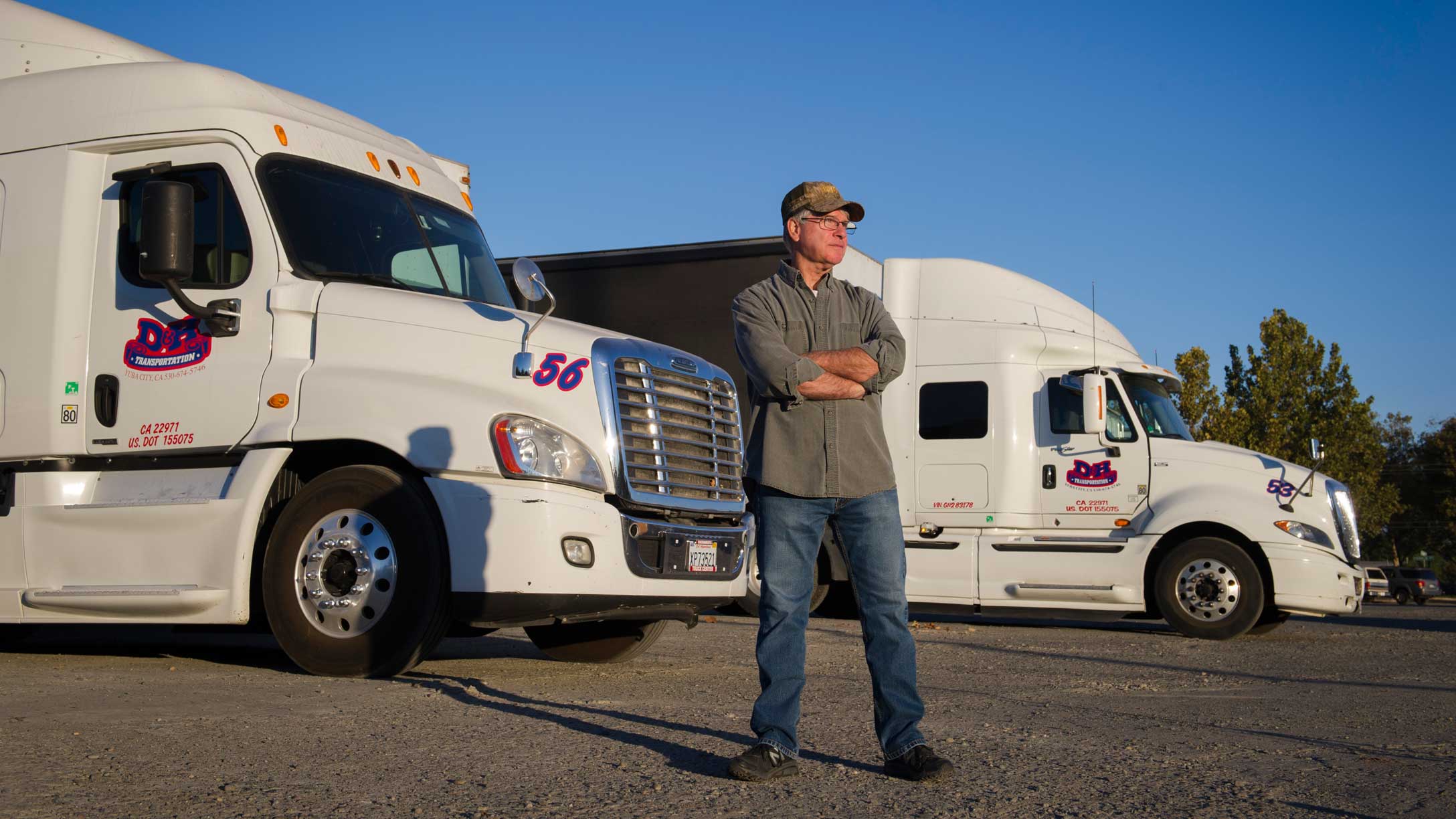 A man standing with trucks in the background. 