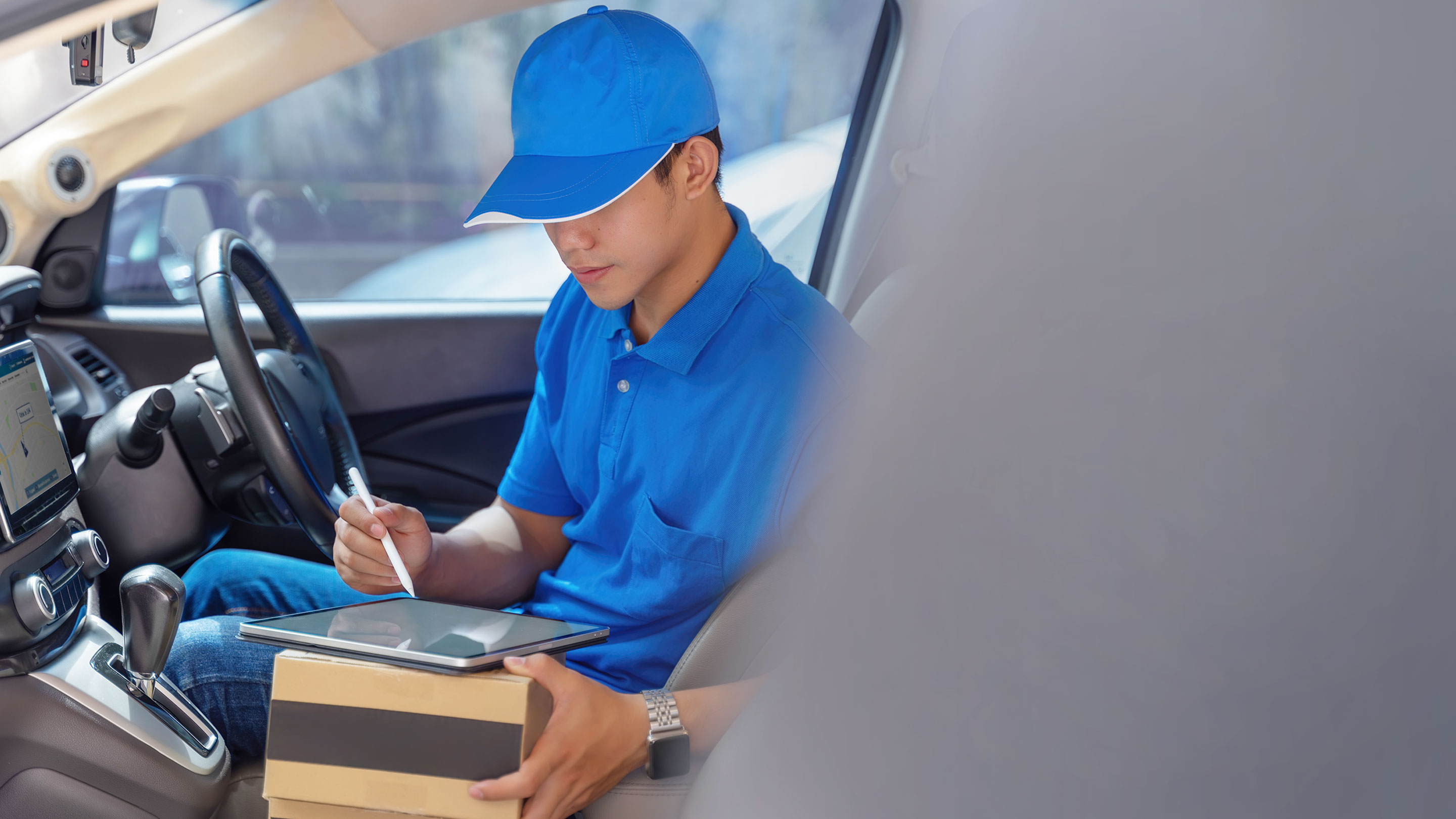 Person using tablet inside their parked vehicle