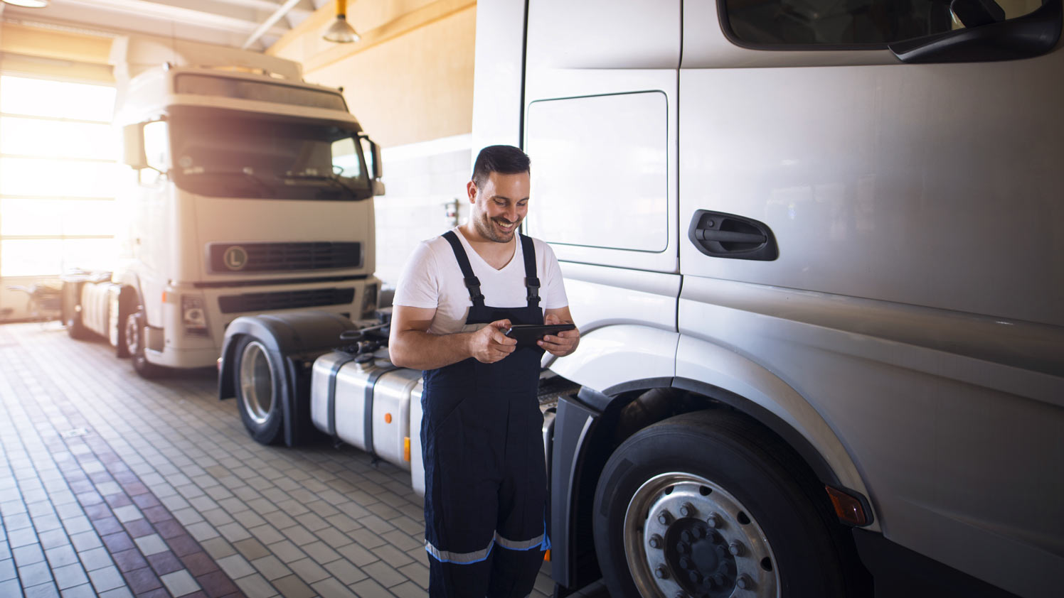 Man walking next to a truck looking at a phone.