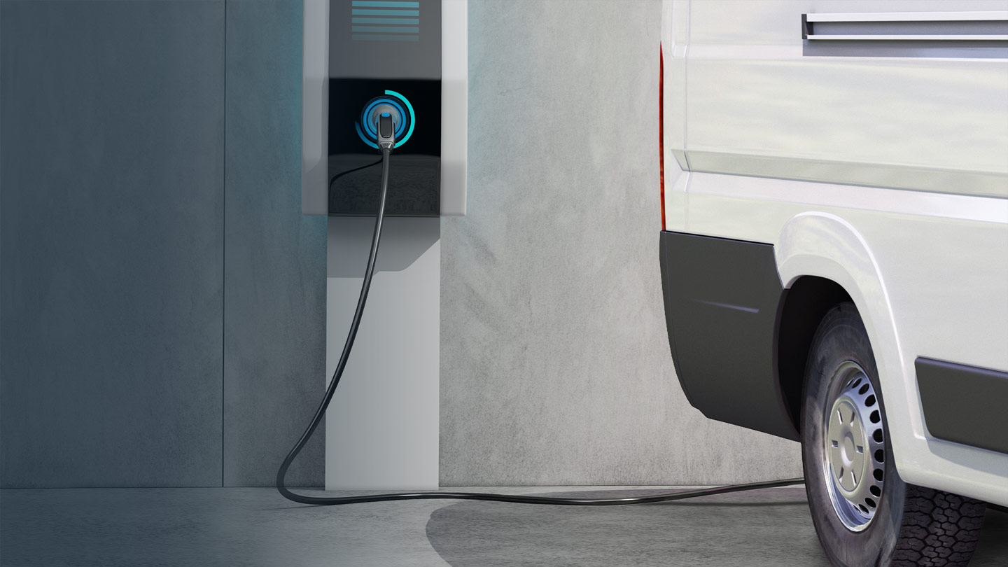 White electric van at a charging station