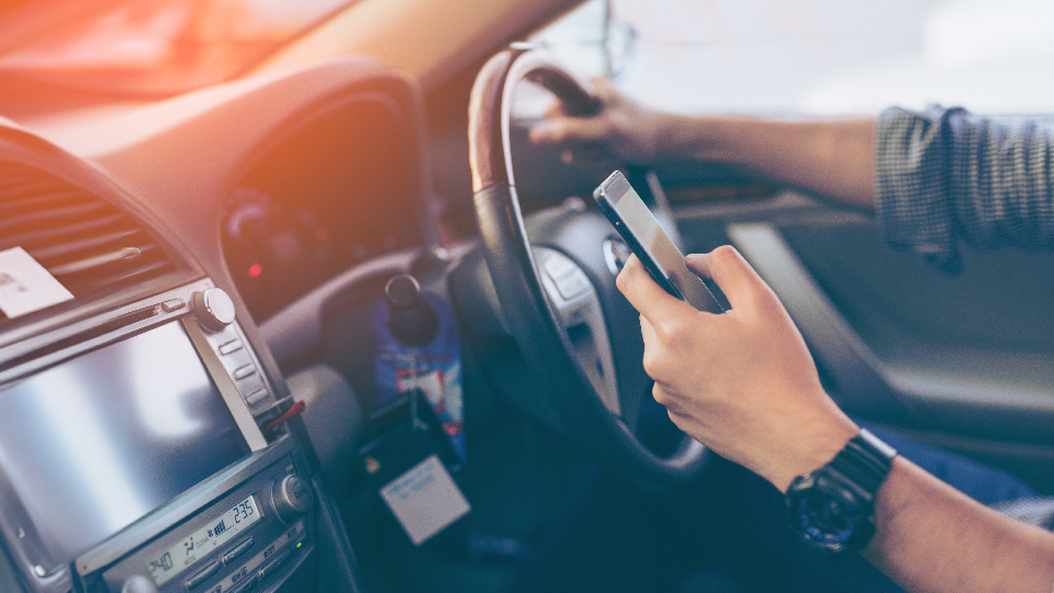 Image of someone using their phone when driving
