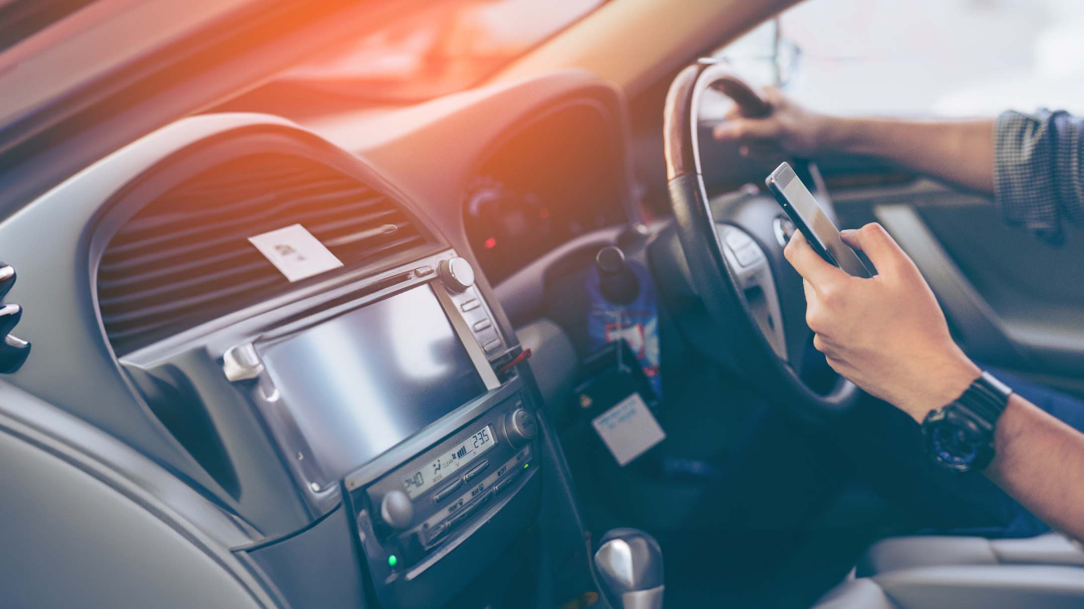 Image of someone using their phone when driving