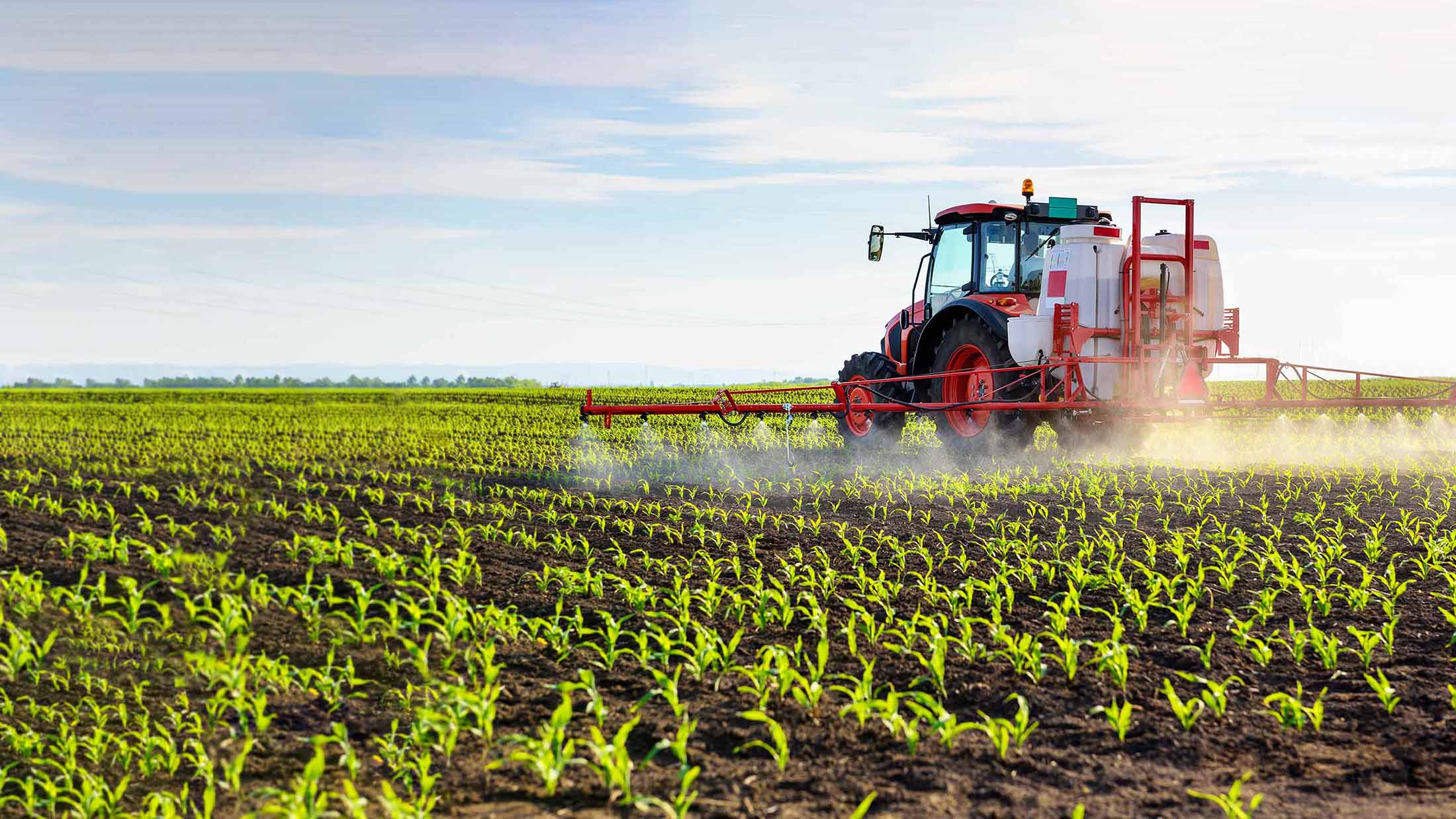 Red irrigation truck watering plants on a farm