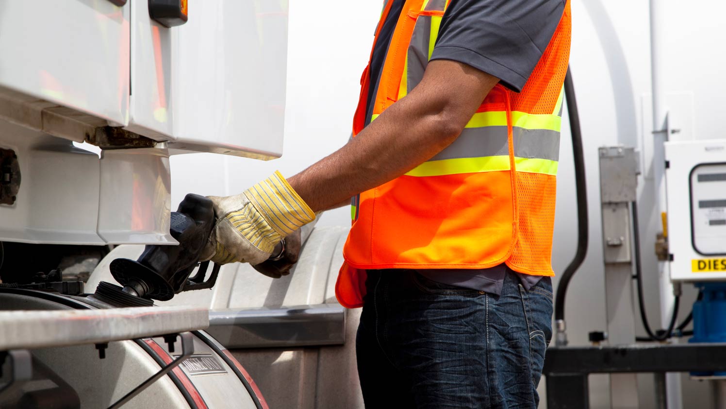 Man in reflective jacket refuelling truck