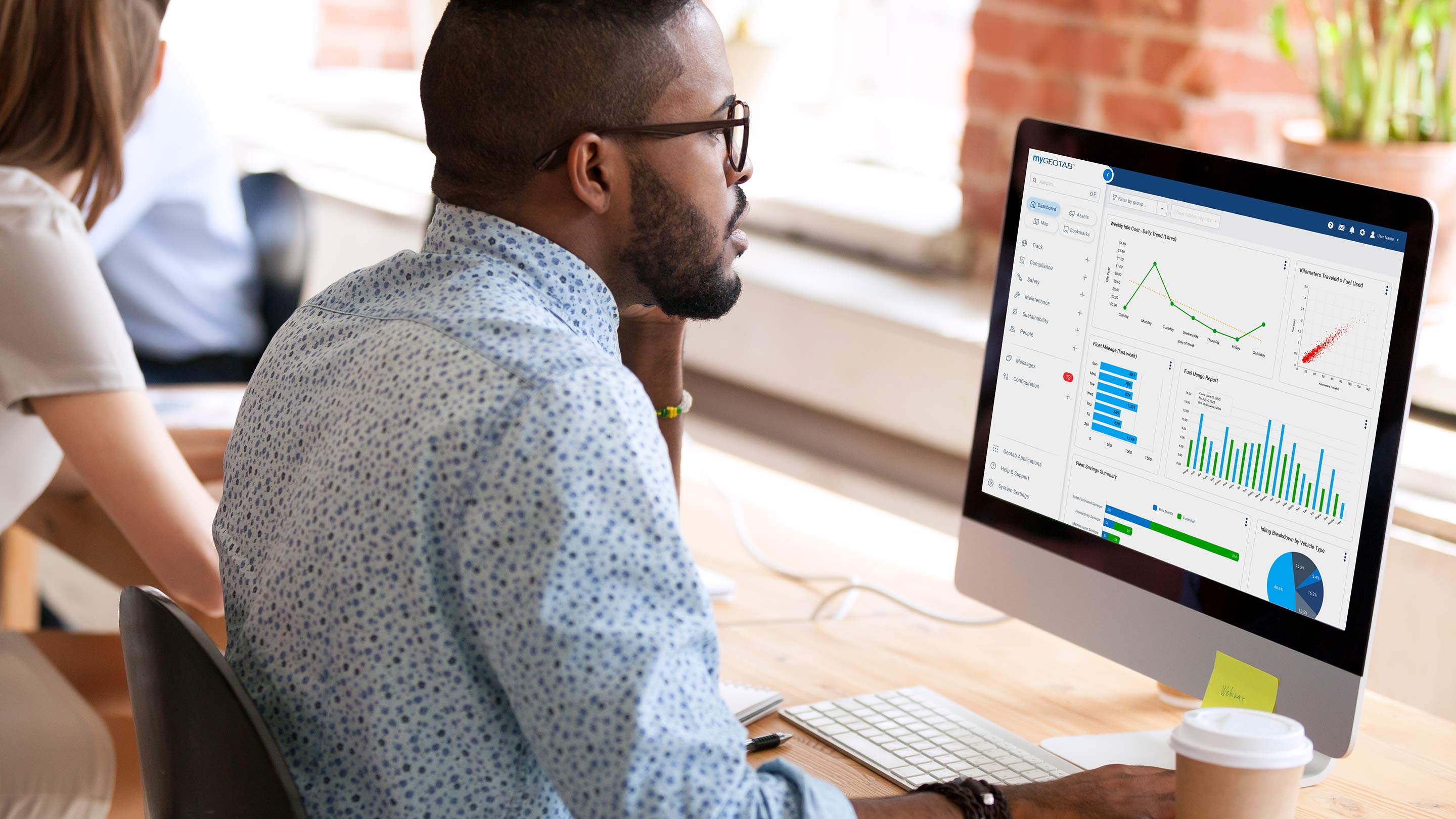 Man using MyGeotab Dashboard on a desktop computer