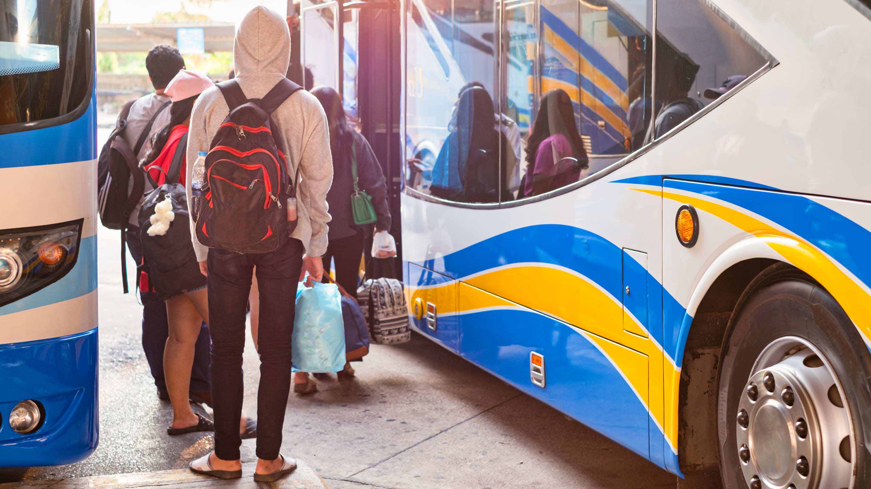 People lining up to get in a bus