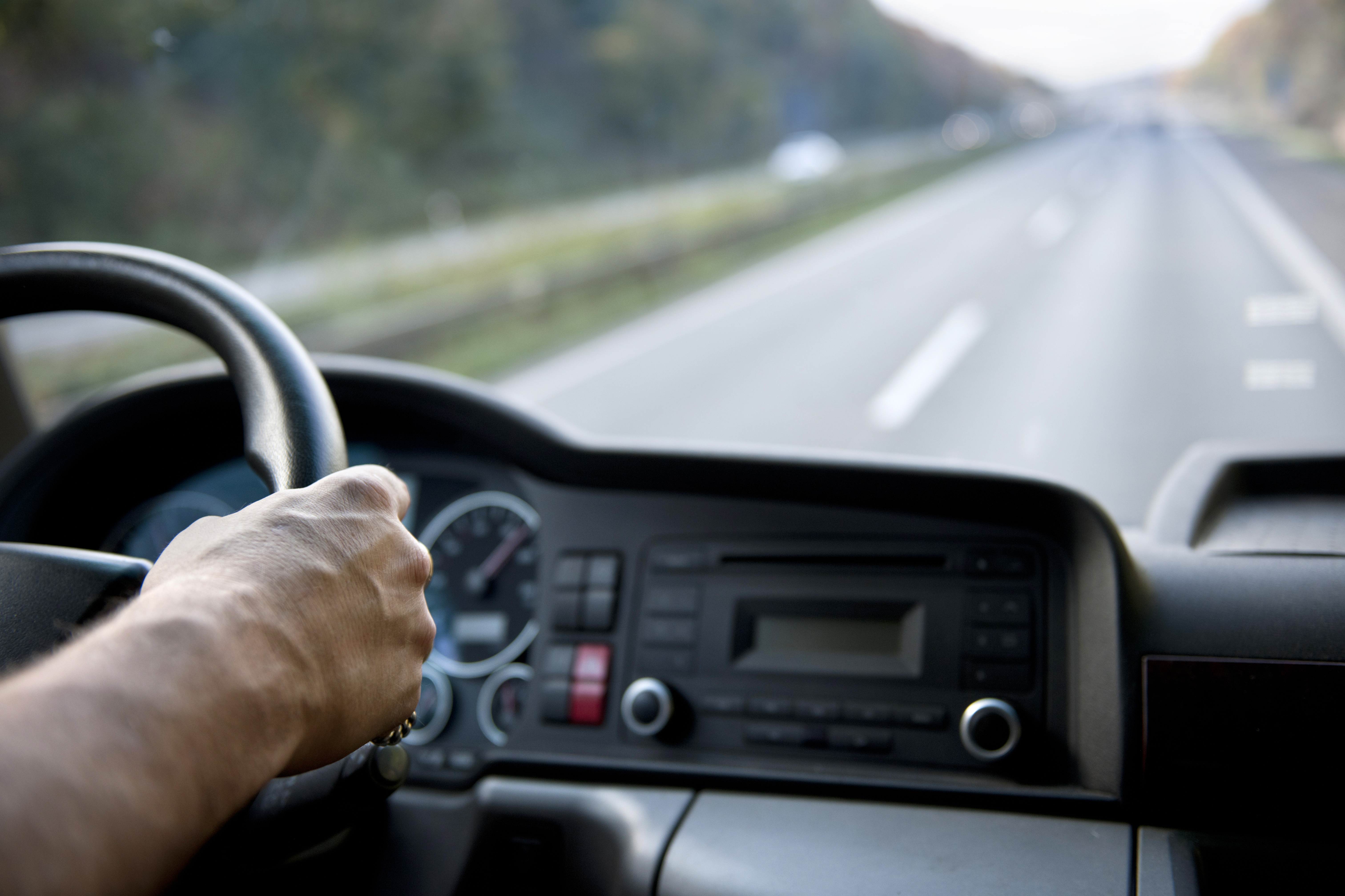 Image of driver behind the wheel on highway