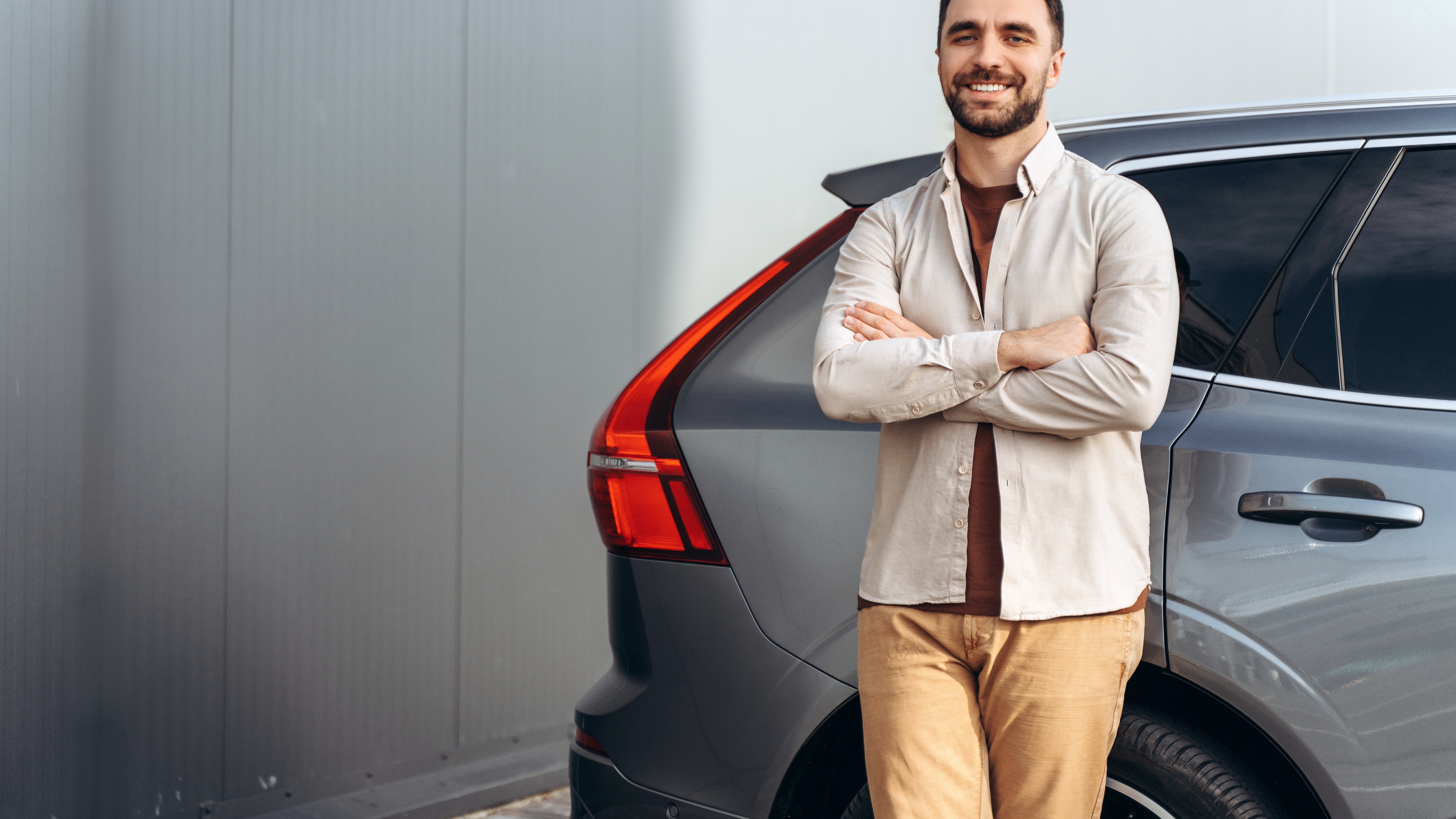 Homme debout à côté d’un véhicule, illustrant la mesure de l’empreinte carbone réelle dans le cadre du scope 3