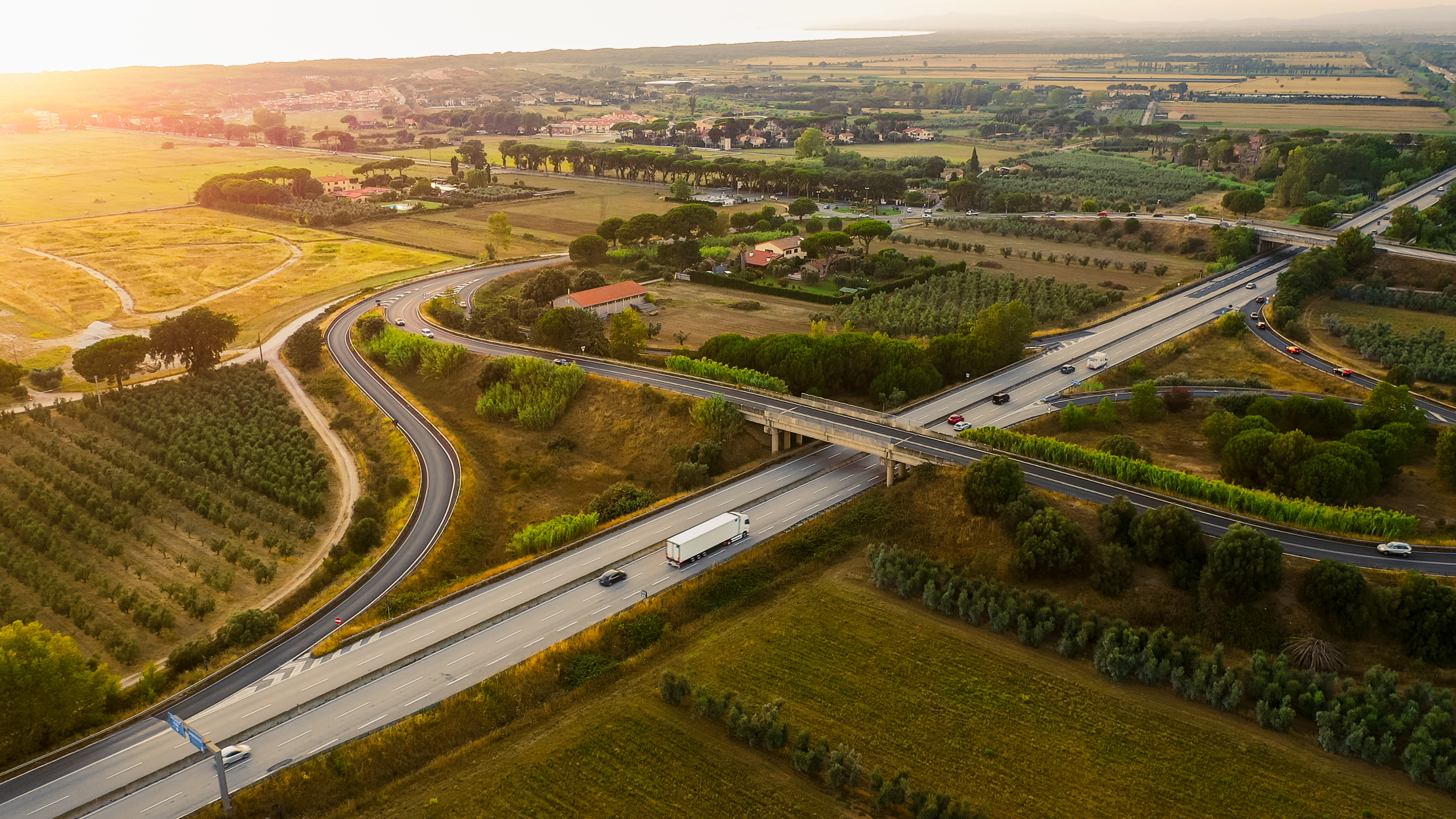 Vue aérienne d’un réseau autoroutier traversant des zones rurales, illustrant les enjeux de mobilité liés à la taxe annuelle incitative TAI