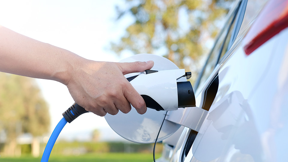 Person charging their white electric car