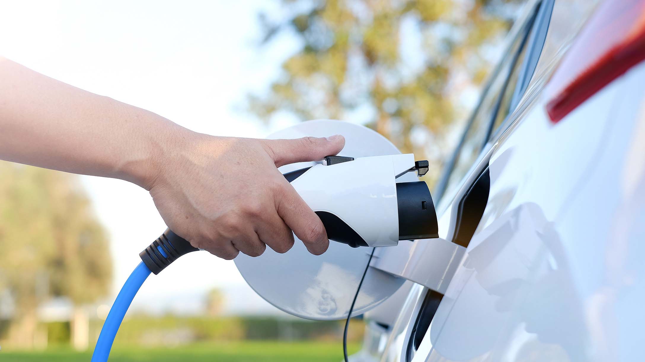 Person charging their white electric car