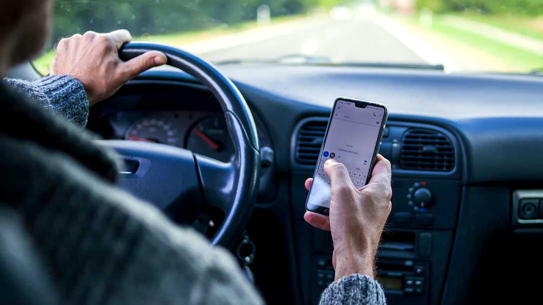 Driver looking at cell phone while driving car 