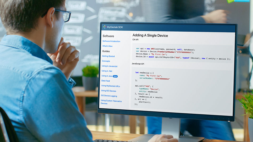 Uomo al computer davanti a una schermata di MyGeotab SDK