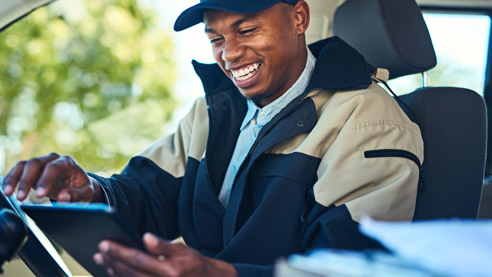 Smiling male driver holding an ELD tablet