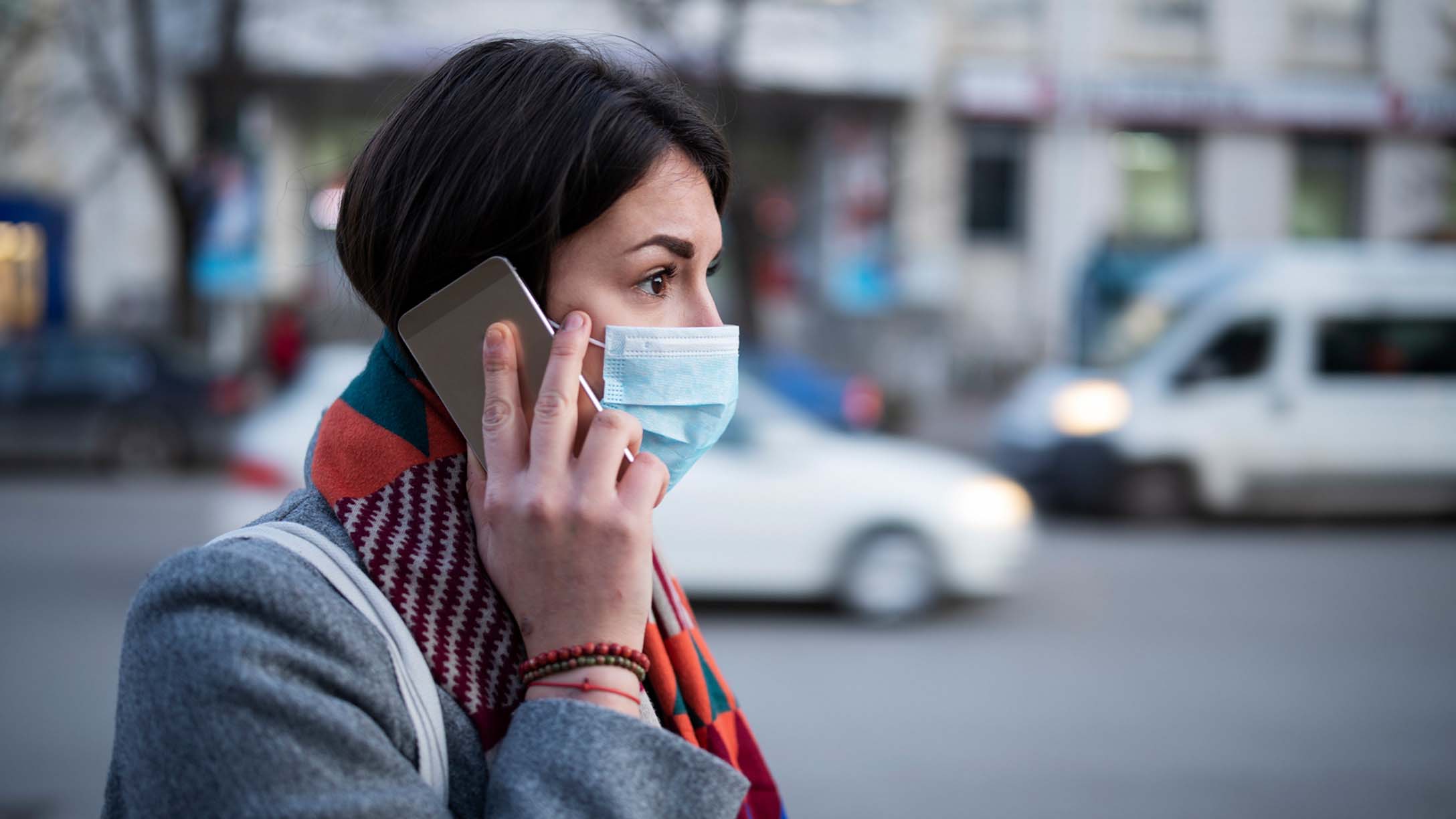 Woman in a mask on a cell phone