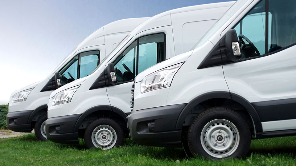 Three white parked vans