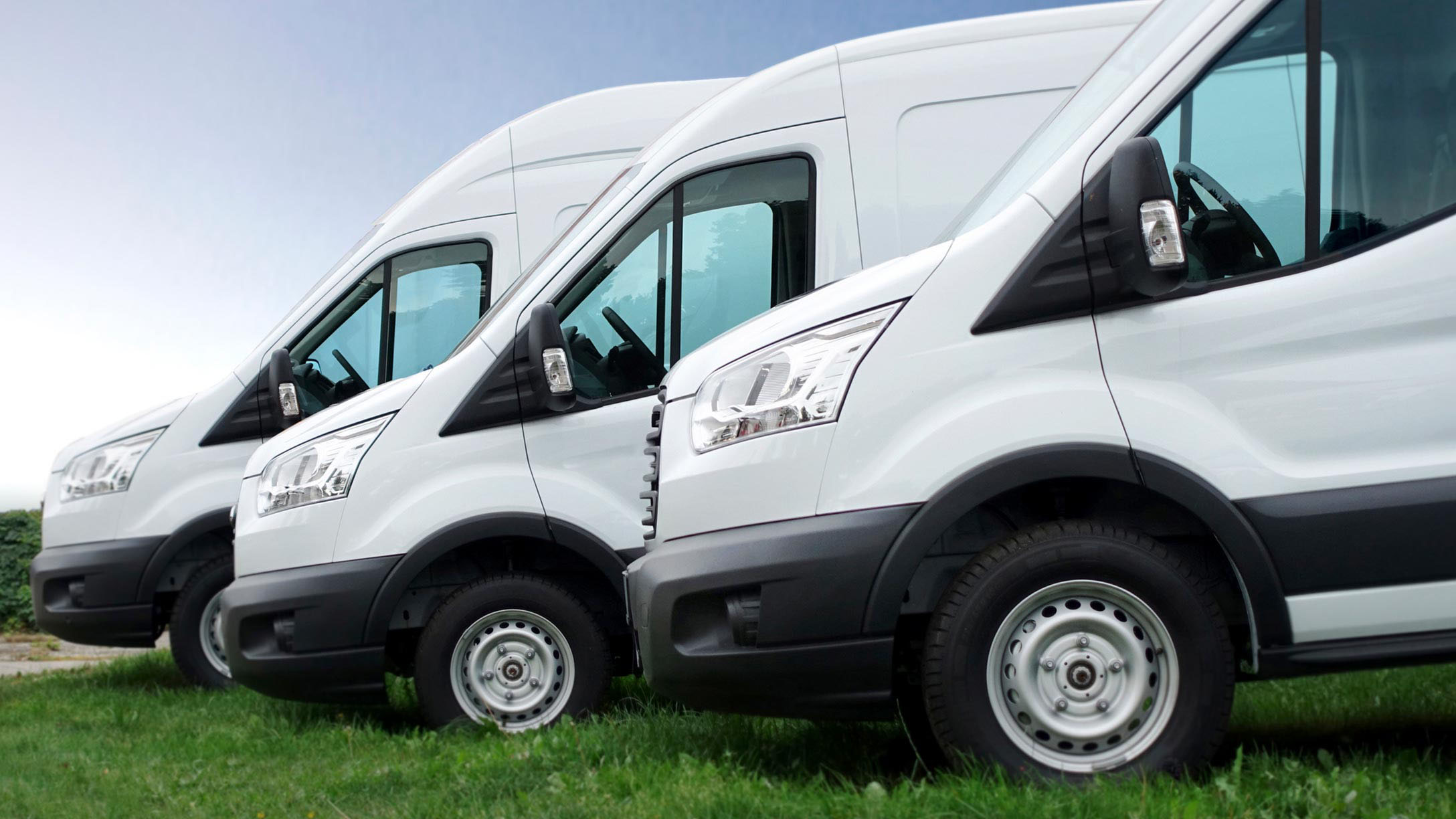 Three white vans parked beside each other