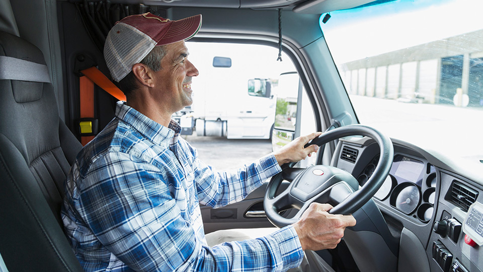 A truck driver at the wheel of a truck