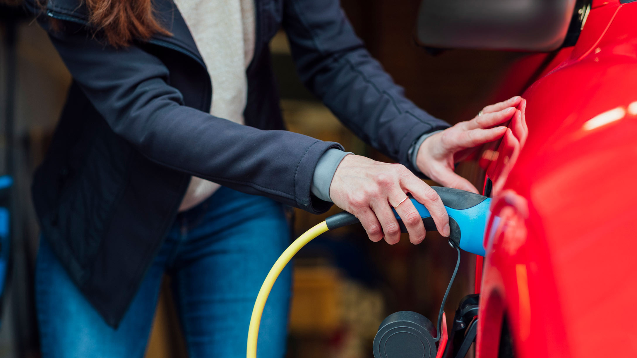 Woman filling up a red EV