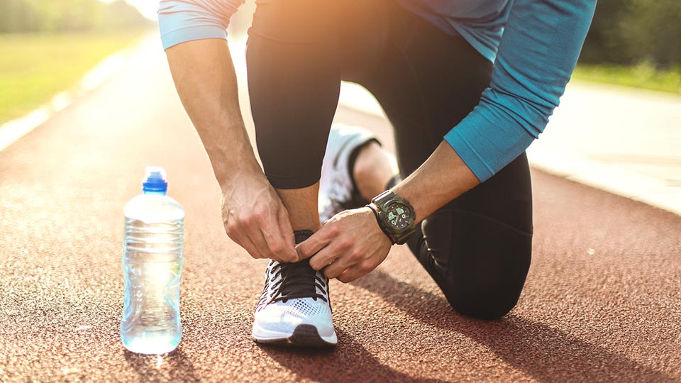 Man on a track tying his running shoes