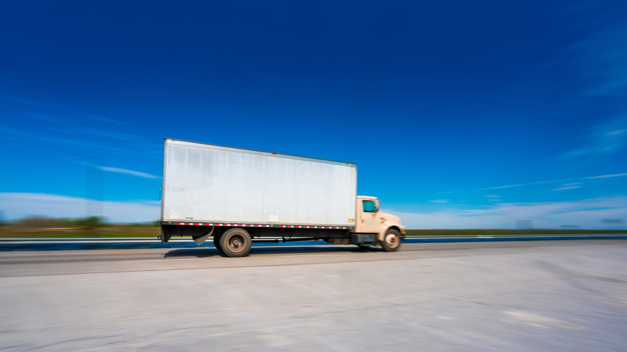 White truck on a road with a blue sky