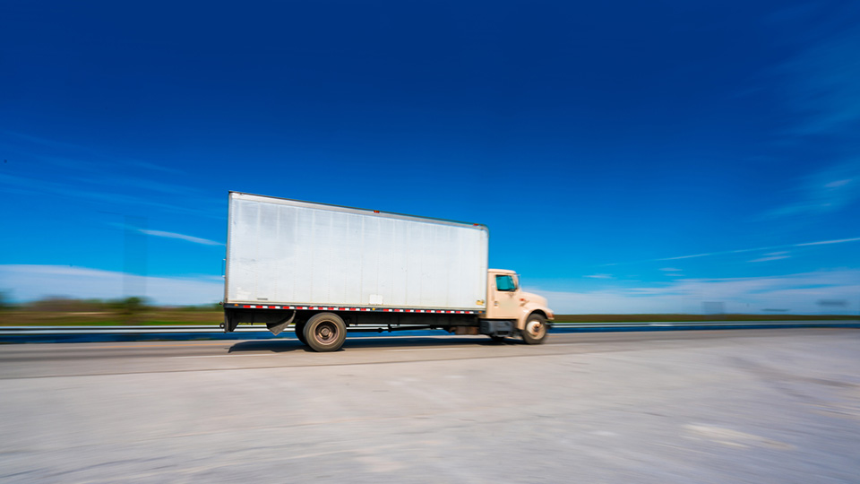 White truck on a road with a blue sky