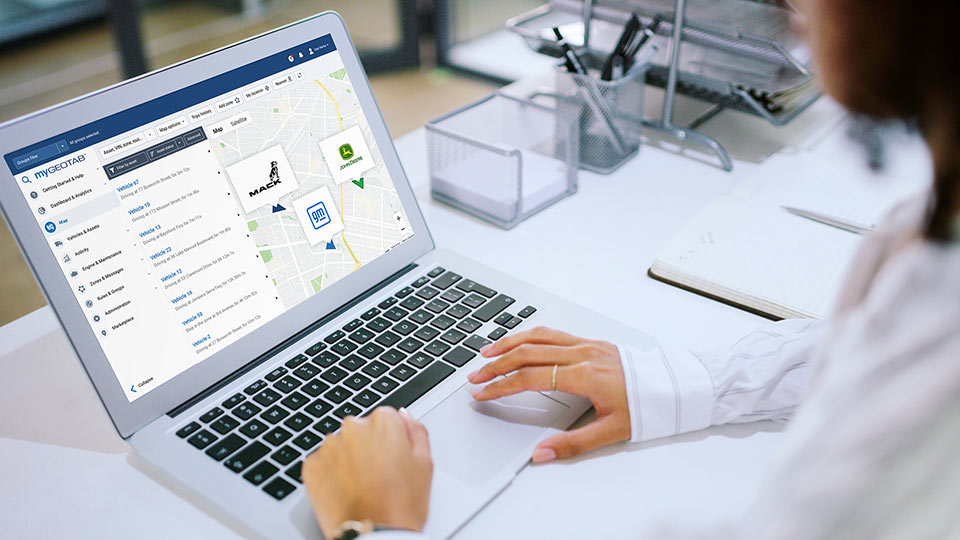 A woman looking at her computer screen which has MyGeotab