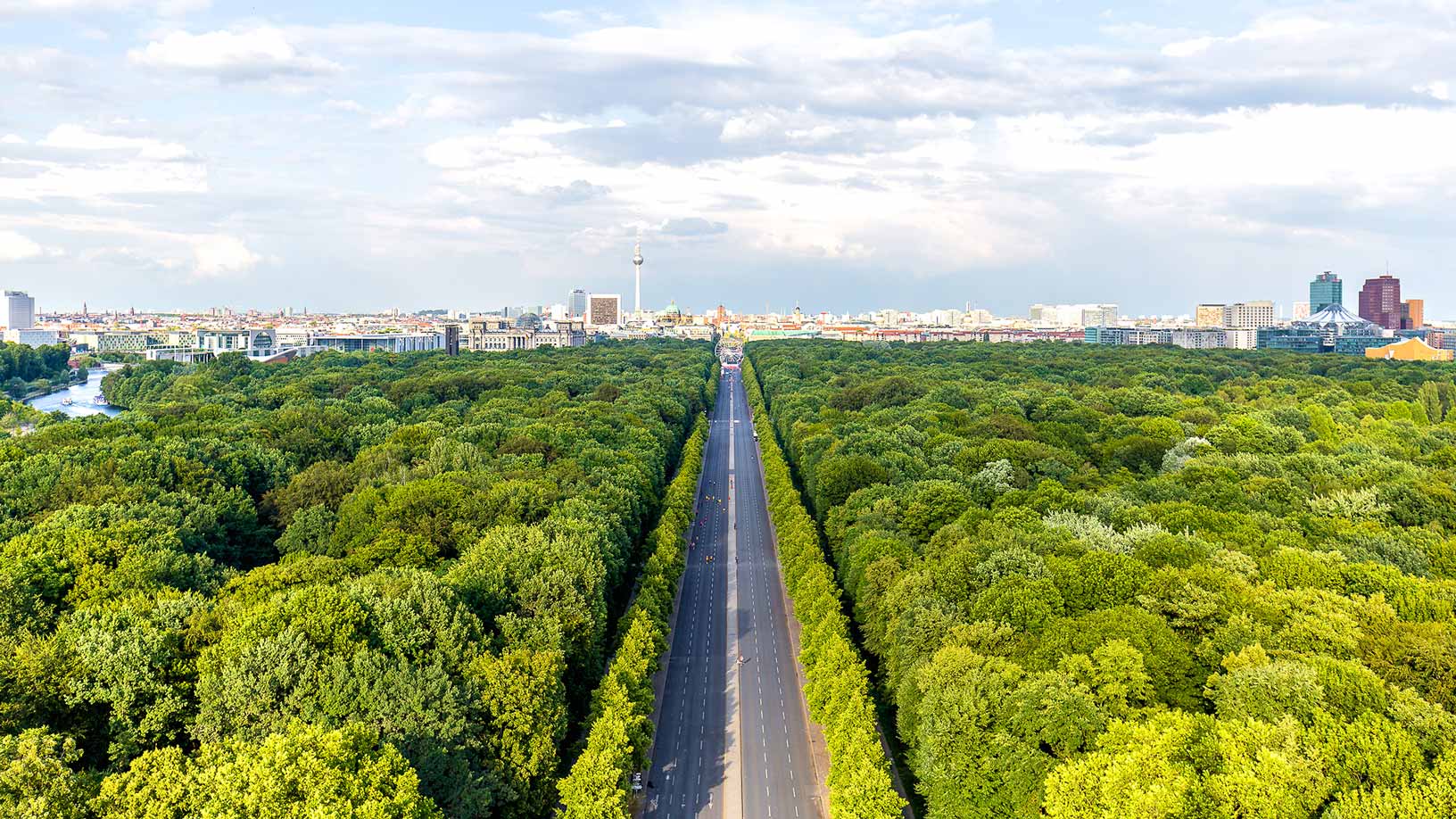 A long road with greenery on both sides