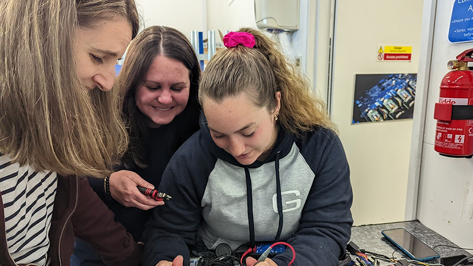 Julia Corcoran (pictured right), senior solutions engineer, soldiers wires to prepare for a device connection.