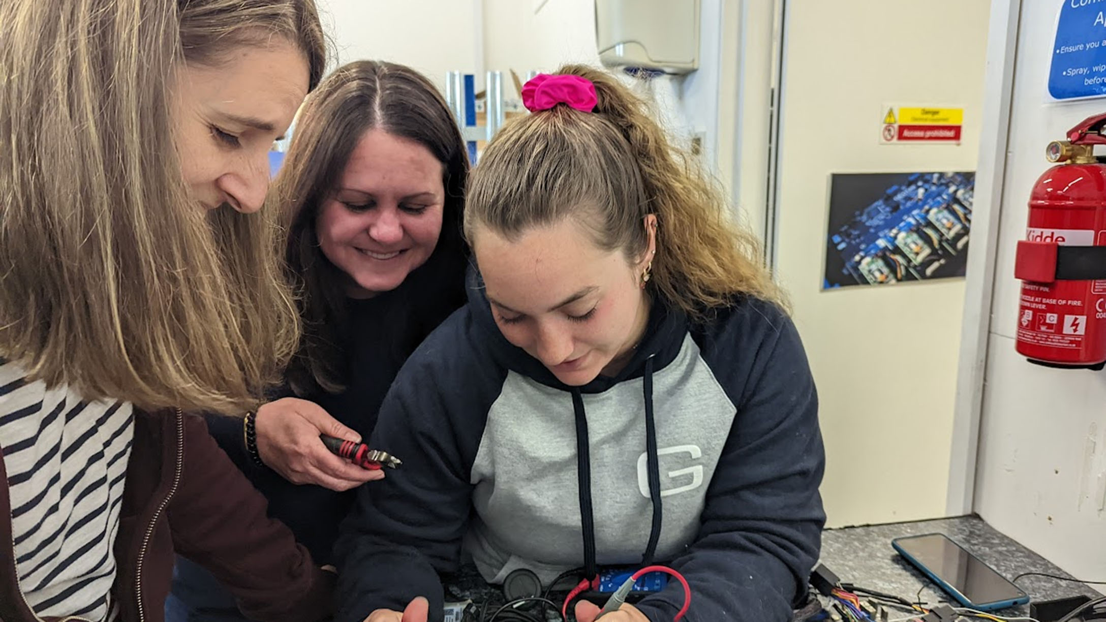 Julia Corcoran (pictured right), senior solutions engineer, soldiers wires to prepare for a device connection.